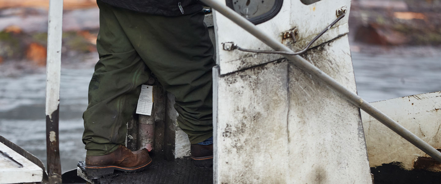 A man on a boot wearing Chippewa boots in brown.